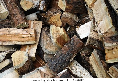 An abstract image of chopped and split firewood stacked loosely in a pile.