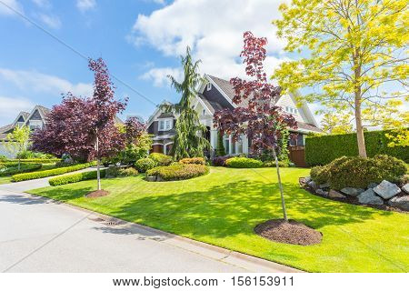 Custom built house with trimmed lawn, yard on a sunny day
