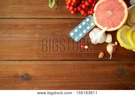healthcare and ethnoscience concept - traditional medicine and drug pills on wooden table
