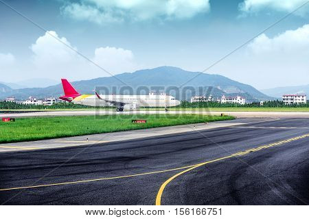 vehicles and ariplane parking in airport ramp in cloudy sky