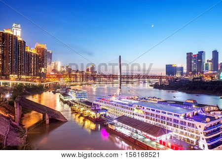 cityscape and skyline of downtown near water of chongqing at night