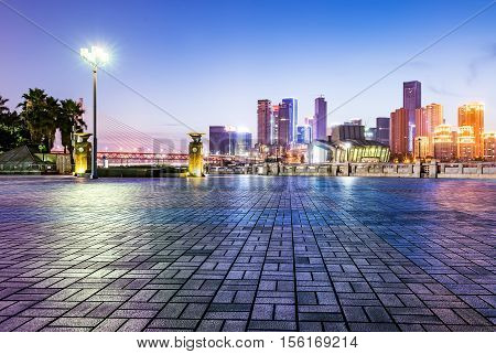 cityscape and skyline of downtown near water of chongqing at night