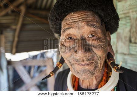 LONGWA, NAGALAND/INDIA - DECEMBER 9, 2013: Tattooed face of elderly former Longwa Village headhunter. Naga tribes practised headhunting & preserved the heads of enemies as trophies.