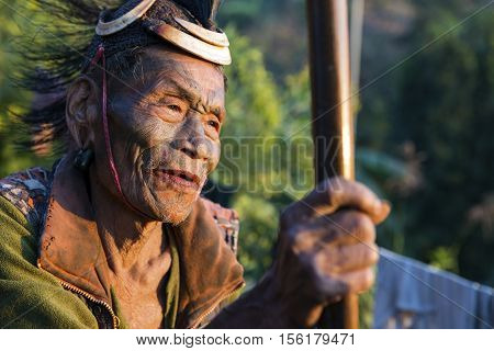 SINGHA CHINGNYU, NAGALAND/INDIA - DECEMBER 8, 2013: Tattooed face of elderly former Singha Chingnyu Village Headhunter. Naga tribes practised headhunting & preserved the heads of enemies as trophies.