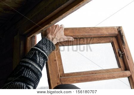 Hand of a worker replacing the old wooden window, cropped angled shot