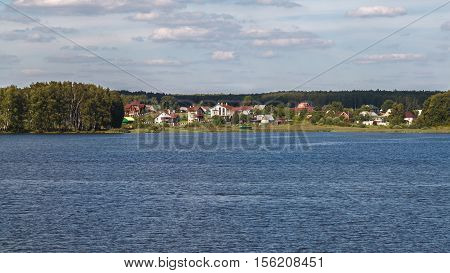 Cottage village on the banks of the river. Summer. Russia.