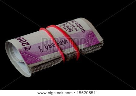 Rolls of the new indian currency. These Rs. 2000 notes are isolated on black and were introduced to curb black money