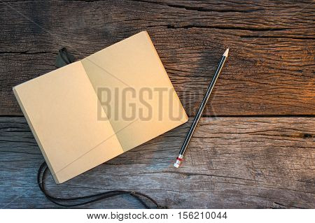 Notebook And Pencil On Old Wooden Table. Top View Of Workplace Writer.