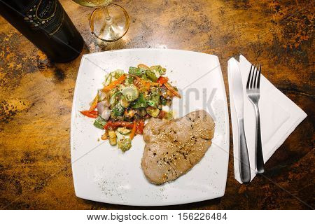 Fillet of tuna with vegetables. With bottle of wine