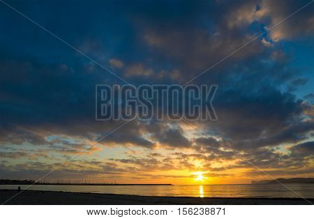 dark clouds over Alghero shoreline at sunset Italy