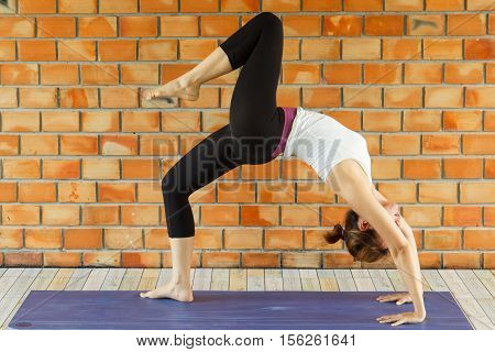 Young woman practicing yoga in a urban background
