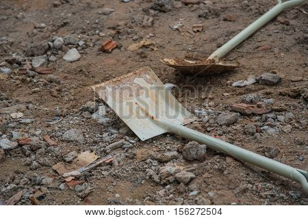 Shovel stuck in a pile of dirt,Construction worker is trying to move a kurb