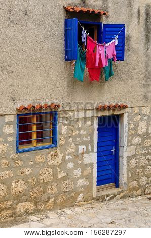 Laundry Driying In Sun, Blue Windows And Blinds