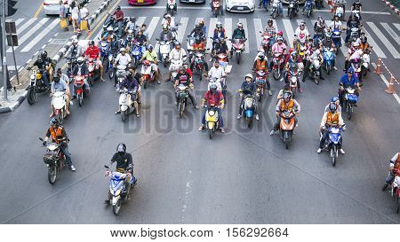 BANGKOK - AUGUST 272016 : Vehicles (motorcycle car taxi and tricycle) wait for a green light at intersection with crosswalk on the city road in Bangkok Thailand.