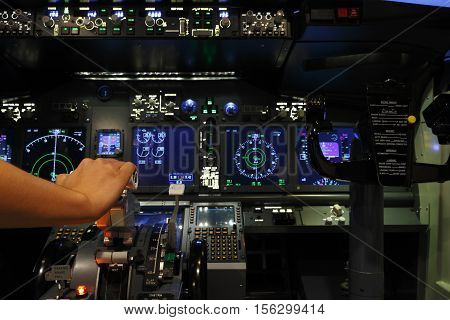 Hand on controller in pilot room of flight simulator