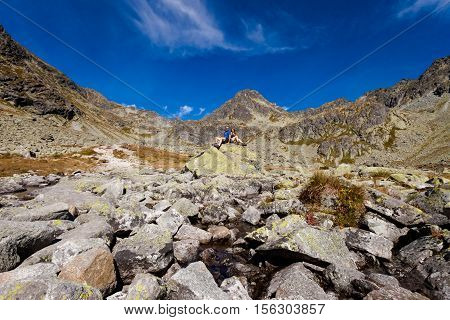 Tourists trekking in Beautiful Mlynicka dolina on the way to Bystre sedlo - in slovakian high Tatra mountains. Summer panorama with great weather and blue sky