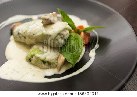 stuffed cabbage in a creamy sauce with basil and tomatoes