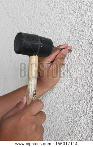 nailing walls with steel spikes and rubber mallet