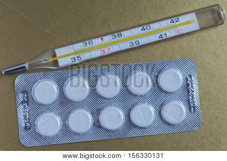 Medical thermometer and pills in the package. The medicine and diagnosis of diseases.