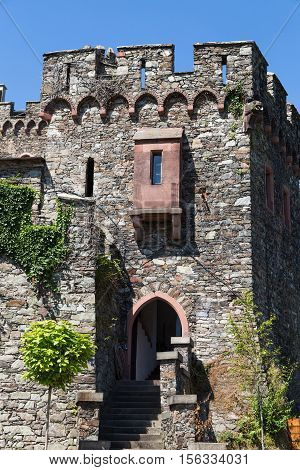 Ancient stone wall with windows stairs and carved turrets against the blue sky. Reichenstein Castle Rhine Valley Germany - UNESCO World Heritage