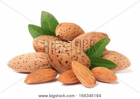 heap of almonds in their skins and peeled with leaf isolated on white background.