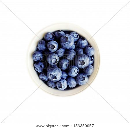 Blueberries in a white ceramic bowl. Top view. Ripe and tasty blueberries isolated on white background.