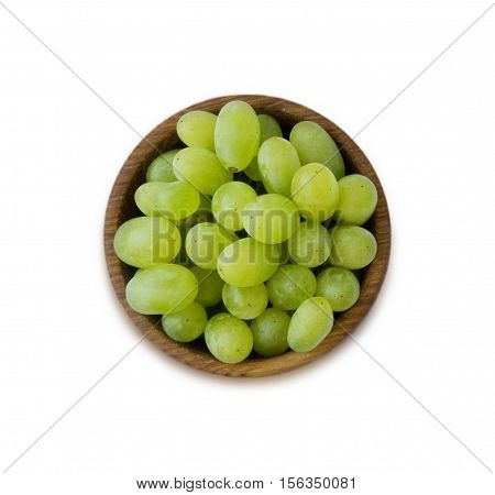 Grapes in a wooden bowl isolated on white background. Green grapes Kish Mish. Top view.