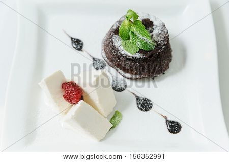 Dessert. Fondan Chocolate and vanilla ice cream. Decorated with mint leaves and raspberries.