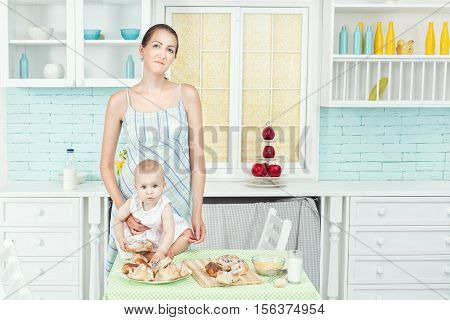 In the kitchen standing at a table mother and her daughter.