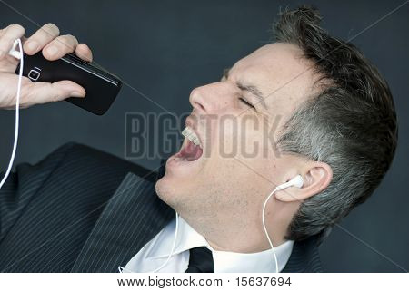 Empresario con los auriculares puestos canta en celular