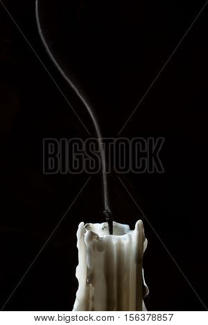 Close up candle with trail smoke on black background