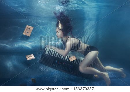 Girl with piano under water on her head headphone.