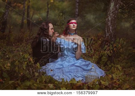 Man kisses a hand of the girl her blindfolded in a retro style.