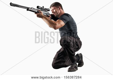 man in black military uniform aiming with rifle isolated on white background
