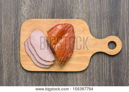 Appetizing bacon sliced on cutting board on wooden table