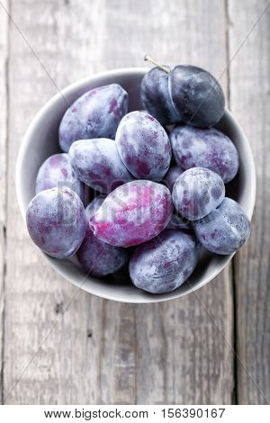 Fresh big plums placed on a wooden table