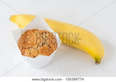 A cup of tasty banana muffin and the key ingredient ripe banana.
