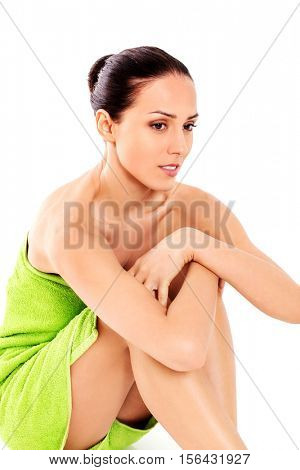 Beautiful woman in towel sitting on the floor