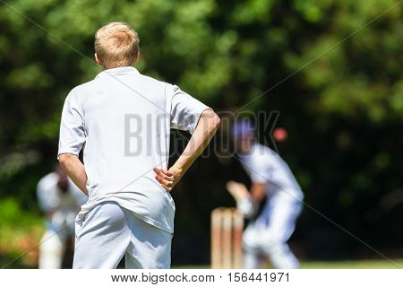Cricket teenagers schools game fielder batsman bat ball action photo.