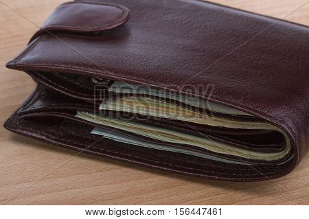closed brown leather men's wallet with money