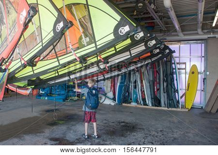 Evanston, IL, USA - June 24, 2016. A boy examines sails for windsurfing