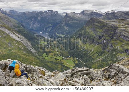 Norwegian fjord landscape. Geiranger village and mountains. Young travelers. Tourism