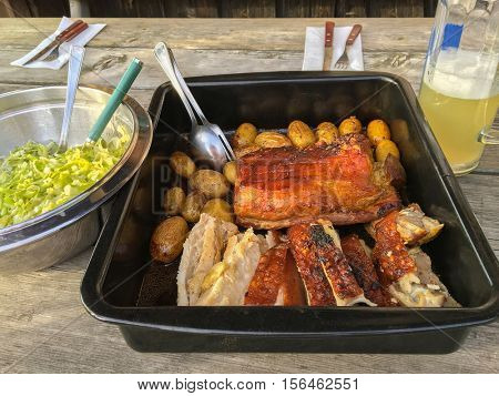Slices of Bavarian freshly roasted pork with crunchy crust (Schweinsbraten) and potato