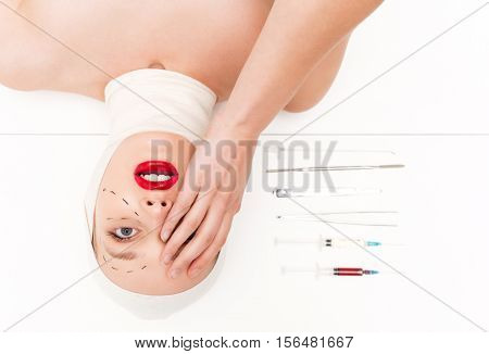 Surprised woman in bandages. isolated white background. with surgical instruments. head over heels