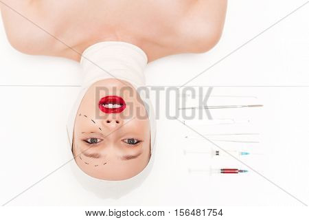 Beauty woman in bandages. isolated white background. with surgical instruments. head over heels