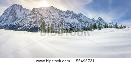 Snowy mountains and valley - Dreamy winter panorama with the Austrian Alps mountains the fir forests and a thick layer of snow over a valley on a sunny day of December.