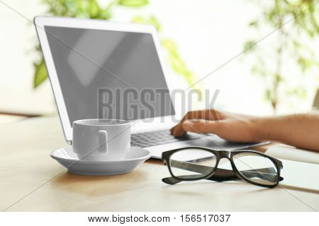 Businessman working place with laptop, glasses and cup of coffee