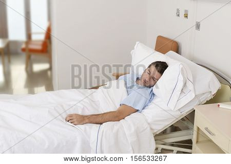 young patient man lying at hospital bed resting and sleeping having serious medical condition disease feeling sick in health care and clinical attention concept