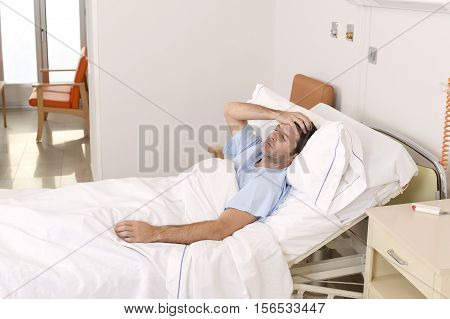 young patient man lying at hospital bed resting tired looking sad and depressed worried about medical condition suffering disease feeling sick in health care and clinical attention concept