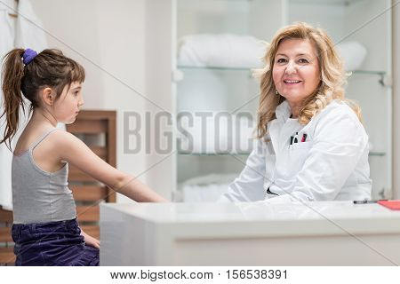 Pediatrician with cute little girl expressing positivity gaining confidence